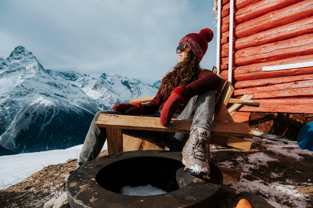 młoda kobieta siedzi przed domem w norweskich górach